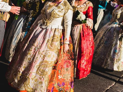 Detalle de la tradicional vestimenta fallera valenciana española, telas coloridas con intrincados bordados.